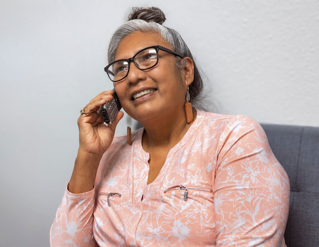 A woman speaking on the phone utilizing the landline phone service provided by Tohono O'odham Utility Authority